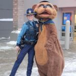 A trooper next to their bear mascot