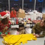 Volunteers tying a yellow blanket
