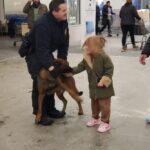 State trooper with a dog and a little girl