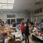 Volunteers next to tables of donations