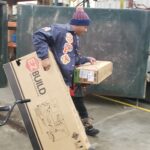 Volunteer carrying 2 boxes
