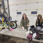 Volunteers with a bike upside down on the table