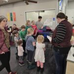 Multiple children gathered around a grocery cart