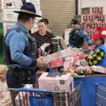 State trooper checking out in Walmart with a grocery cart full of toys