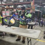 A volunteer holding a blue bike