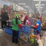 Santa checking out an elf at the check out line
