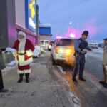 Santa and a state trooper talking to 2 individuals