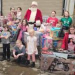 Kids with santa with multiple carts with toys in them