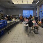 Volunteers next to tables with toys