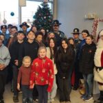 Multiple volunteers, santa, and state troopers