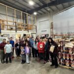 Over 20 volunteers standing next to food