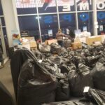 A lot of black bags with volunteers in the background